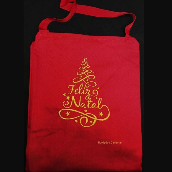 Avental vermelho com bordado a dourado de árvore Feliz Natal.