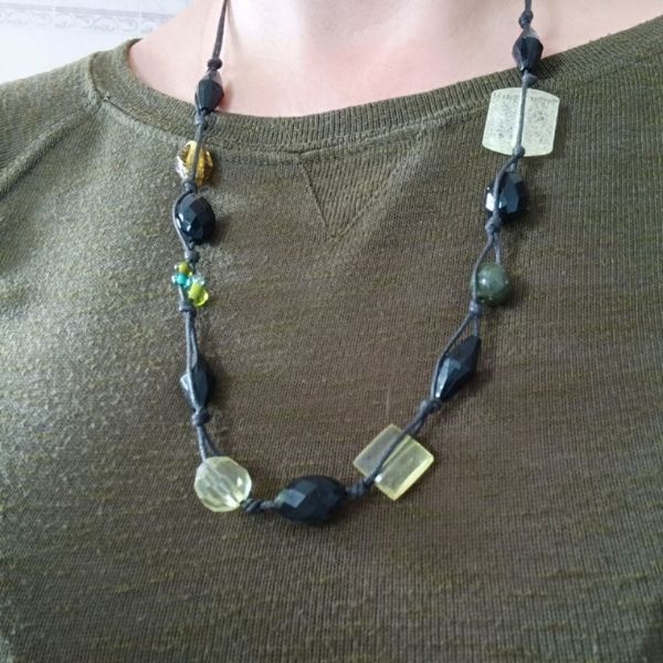 Colar em fio de algodão com contas pretas e verdes.