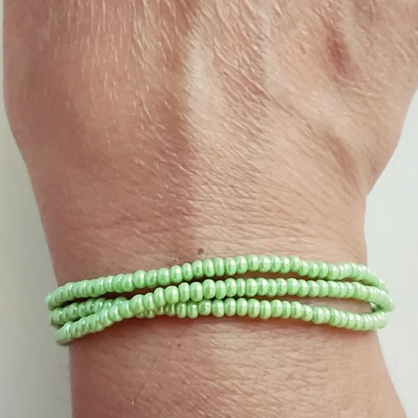 Conjunto de três pulseiras de missangas verdes.