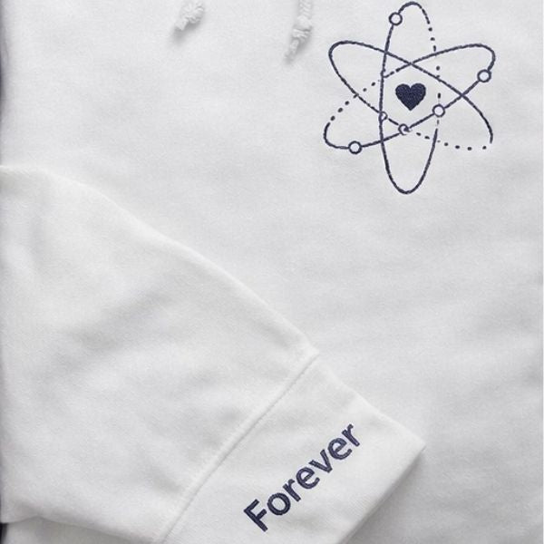 Pormenor do bordado átomo do amor e a palavra Forever.