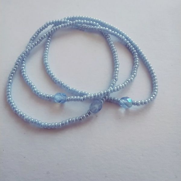 Conjunto de três pulseiras de missangas aziuis.