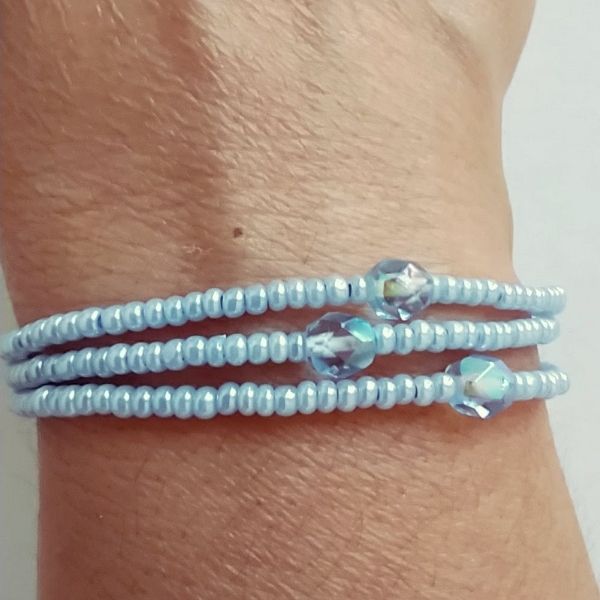 Conjunto de três pulseiras de missangas azuis.
