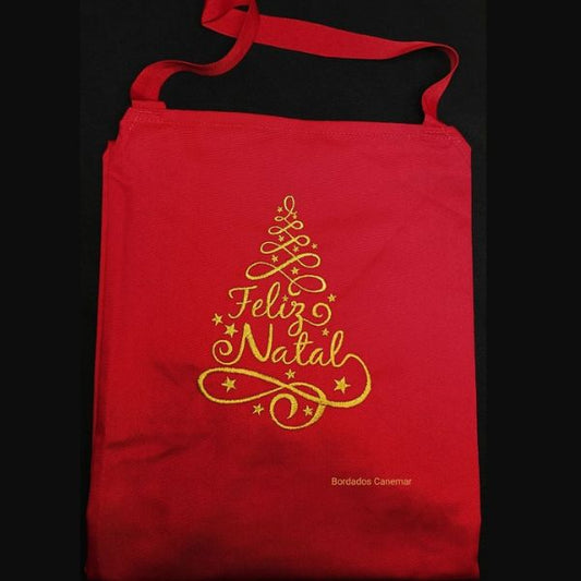 Avental vermelho com bordado a dourado de árvore Feliz Natal. 