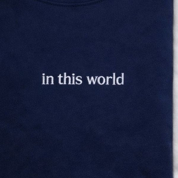 Camisola azul marinha com bordado In this world.