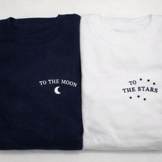 Camisolas bordadas, uma com a frase To the moon e a outra com a frase To the stars.