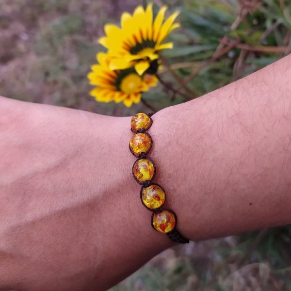 Pulseira com contas amarelas raiadas.