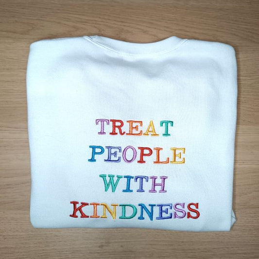 Fotografia da parte de trás de sweatshirt que está bordada com frase "Treat people with kindness", título da música de Harry Styles.