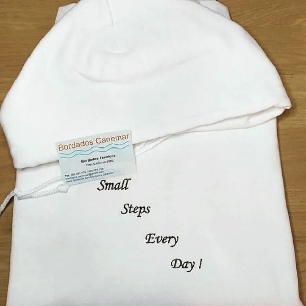 Sweatshirt branca com bordado "Small steps every day!" a preto.