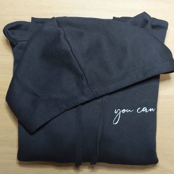 Sweatshirt com capuz preta com "You Can" bordado na zona do peito a branco.