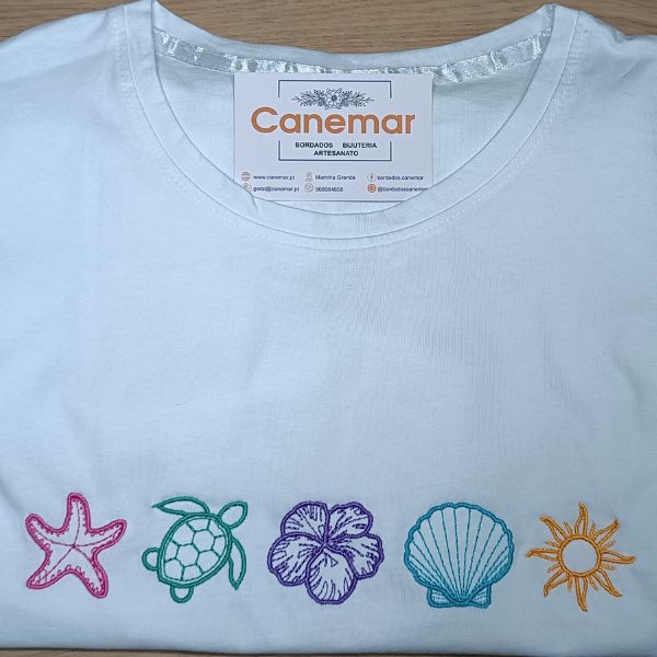 T-shirt branca bordada com estrela do mar, tartaruga, hibisco, concha e sol, cada um da sua cor.