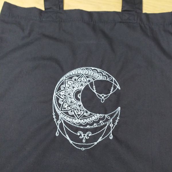 Tote bag preto com "Mandala Lua" bordada a branco.
