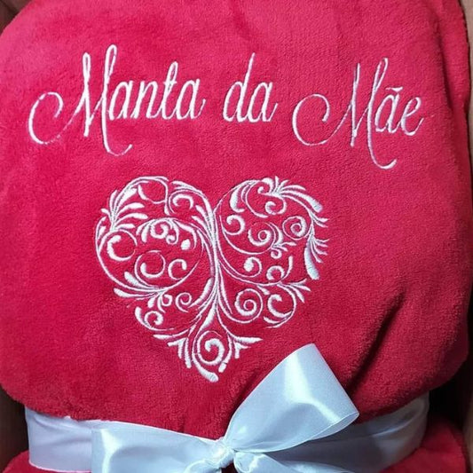 Manta vermelha com coração bordado a branco e com frase "Manta da Mãe".