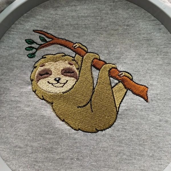 Pormenor do bordado em t-shirt cinza matizada, de "Preguiça".