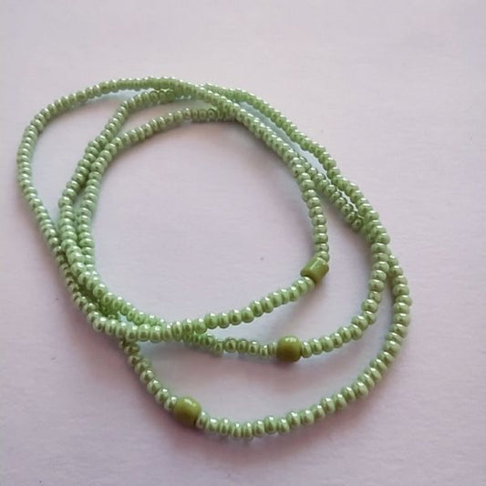Conjunto de três pulseiras de missangas verdes.